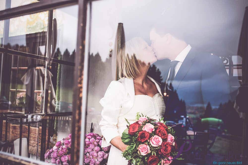Wedding couple behind glass pane