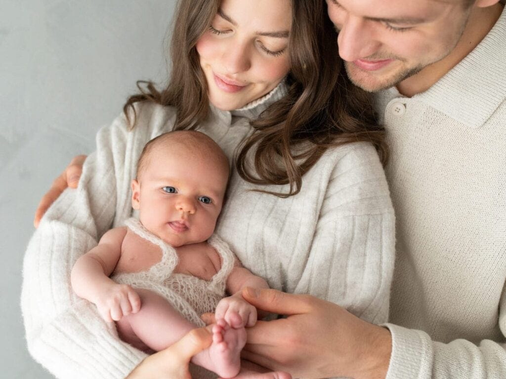 Sanfte Babyhaltung mit glücklicher Familie, Nahaufnahme eines Babys, Elternliebe, Familienfotografie