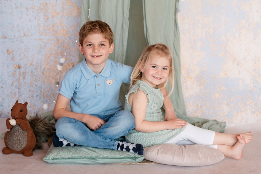 Niedliche Kinder spielen zu Hause, kreative Fotoshooting, kindliche Fröhlichkeit, Kinderfotografie, gemütliches Zuhause.