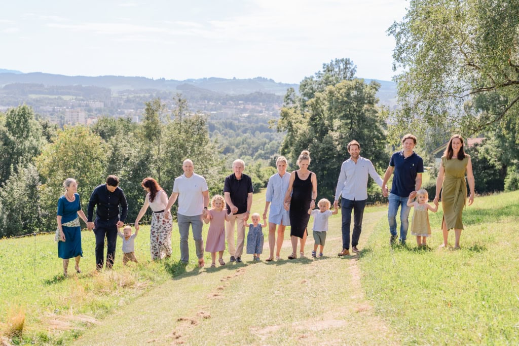 Familienfoto beim Spaziergang im Grünen an einem sonnigen Tag