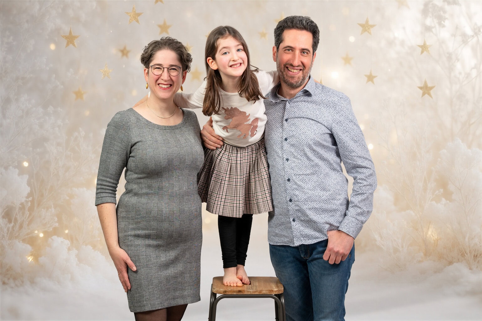 Familie bei fotoshoot, weihnachtliche hintergrund, glückliche familie, kinderfoto, familienaufnahme, familien portrait, lustige familienfotos, fotograf in münchen, professionelle familienfotografie, kinder und eltern, familie mit kind, festliche stimmung, einzigartige familienbilder, familienzeit.