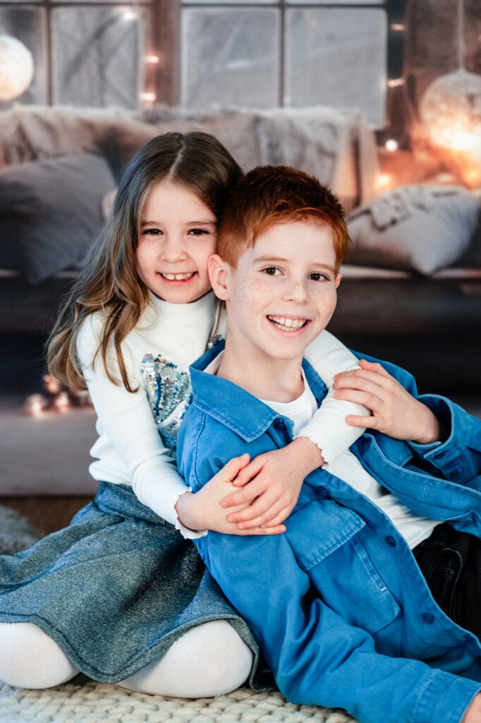 Lachende Geschwister beim Weihnachts-Fotoshooting München im Studio