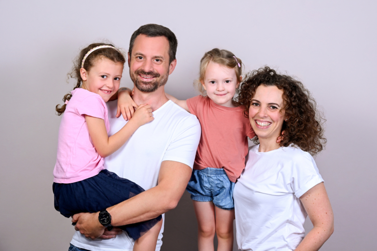 Smiling family during a professional photo shoot in the photographer's studio in Munich, Germany.
