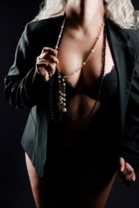 Elegantes Boudoir-Foto mit Blazer, Spitzen-BH und Perlenkette