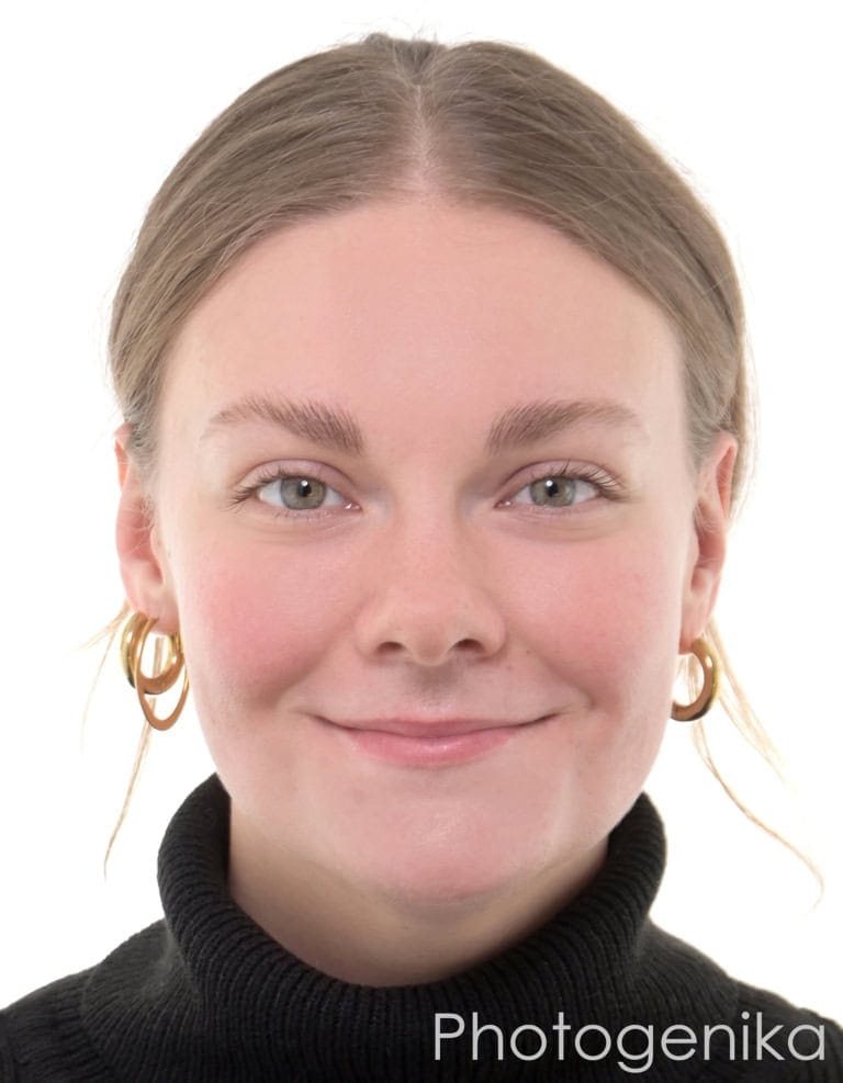 Biometrisches Passbild einer jungen Frau im schwarzen Rollkragenpullover mit Creolen.